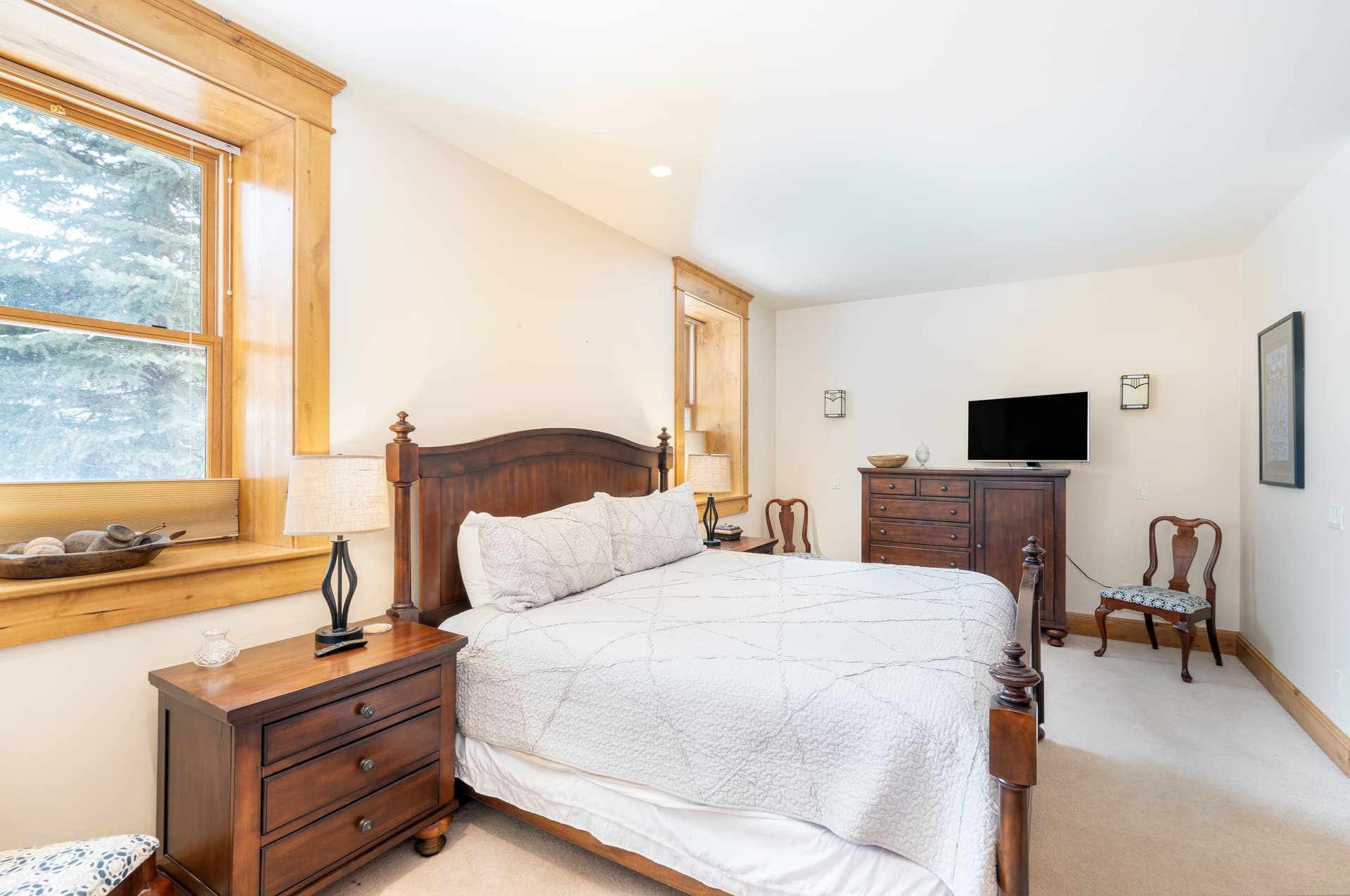 Primary bedroom with dresser and HD TV