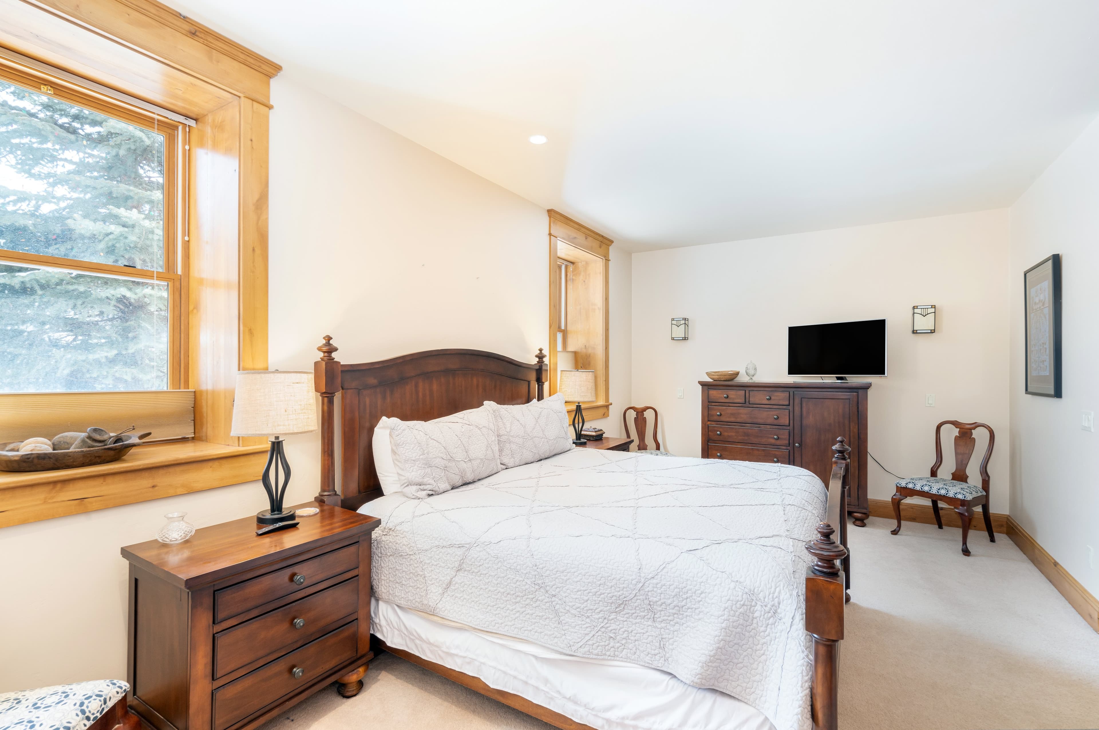 Primary bedroom with dresser and HD TV