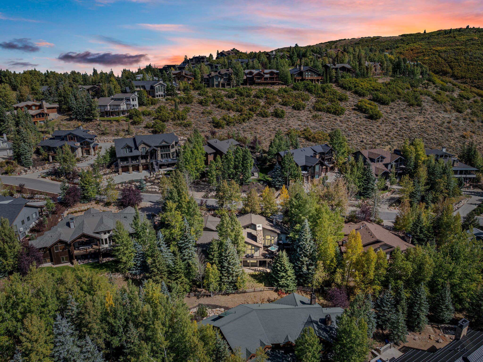 Aerial View of Home Area with Surrounding Houses and Wooded Landscapes.
